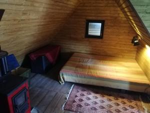a bedroom with a bed in a wooden room at Cabana Farmec Ciubăr - Dézsabáj Kulcsosház in Sovata +8 photos