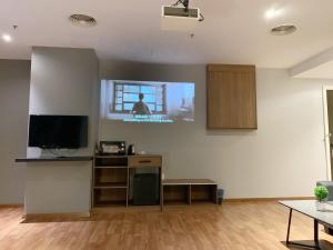 un soggiorno con una TV a schermo piatto su una parete di The Luxmi - Bangsar Trade Centre a Kuala Lumpur