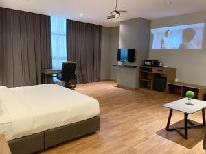 una camera d'albergo con un letto e una TV a schermo piatto di The Luxmi - Bangsar Trade Centre a Kuala Lumpur