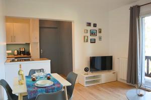 a living room with a dining table and a television at Domaine La Castilha in Biscarrosse