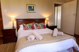 een slaapkamer met een bed met handdoeken erop bij Landskroon Cottage in Paarl