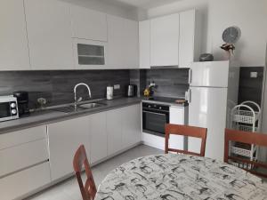 a kitchen with white cabinets and a table and chairs at Apartments Marijana in Zavalatica