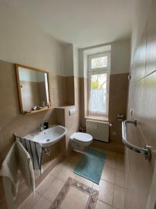 a bathroom with a sink and a toilet and a mirror at Wohnen im historischen Gebäude der Kaiserzeit in Wismar
