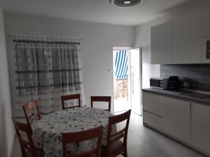 a kitchen with a table and chairs in a room at Apartments Marijana in Zavalatica