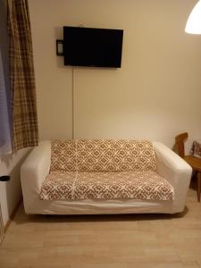 a white couch in a living room with a flat screen tv at Gasthof zum Pfandl in Bad Ischl