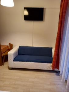 a living room with a couch with a blue cushion at Gasthof zum Pfandl in Bad Ischl