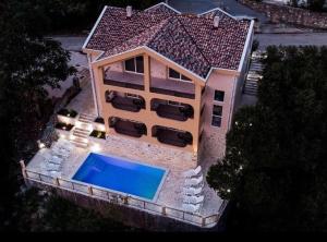 Cette chambre offre une vue sur une maison dotée d'une piscine. dans l'établissement Apartments Casa Bella, à Kotor