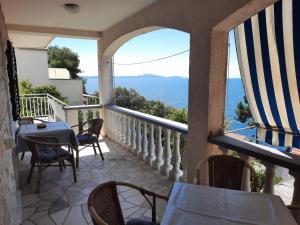 a balcony with chairs and tables and a view of the ocean at Apartments Marijana in Zavalatica