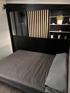 a bed with a black headboard in a room at Benne insolite in Brignoles