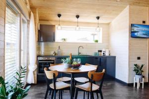 a kitchen with a table and chairs in a kitchen at Holiday Houses LILLE`S with sauna in Alūksne