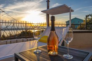 a bottle of wine sitting on a table with two wine glasses at Sun Villa in Dramalj