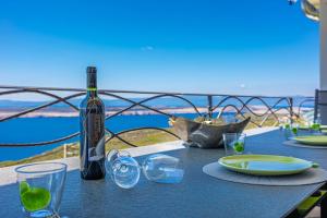 een fles wijn op een tafel met glazen bij Sun Villa in Dramalj