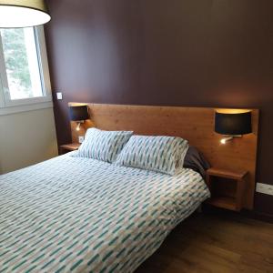 - une chambre avec un lit avec deux oreillers et deux lampes dans l'établissement ARC 1800 Appartement 6-8 pers,5 cristaux, avec garage, à Arc 1800