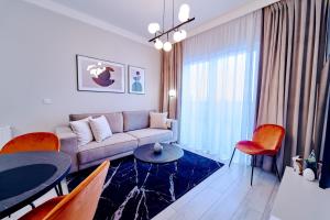 ポラニツァ・ズドルイにあるLAGUNA Apartament Polanica Residence 3のリビングルーム(ソファ、テーブル、椅子付)