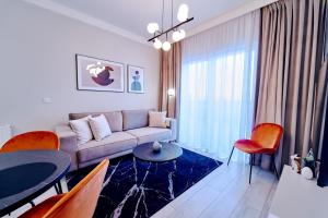 a living room with a couch and a table and chairs at LAGUNA Apartament Polanica Residence 3 in Polanica-Zdrój +34 photos