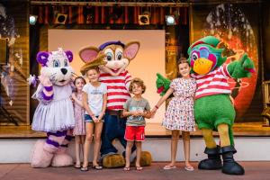 a group of children standing next to mascots on a stage at MOBIL HOME SERENITE 2CH VALRAS PLAGE in Valras-Plage