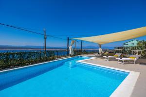 a swimming pool with a view of the ocean at Sun Villa in Dramalj