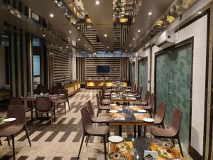 comedor con mesas y sillas y TV en Sapphero Resorts, en Shirdi