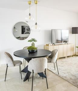 a dining room with a black table and chairs at DJC - Modern 2 bedroom apartment close to beach in Casares