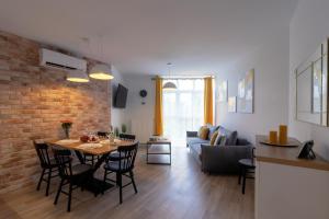 Il comprend une cuisine et un salon avec une table et des chaises. dans l'établissement Apartamenty NCNK Osiedle Bursztynowe w Jantarze, à Jantar