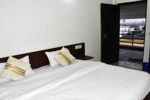 um quarto com uma grande cama branca e uma janela em Corbett Bhavesh home Stay em Jhirna