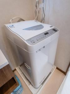 uma máquina de lavar e secar num quarto em HANASTAY花渓居 · 澄（KIYOSI) em Osaka