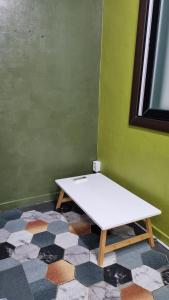 a white table sitting on a floor in a room at Jungle guesthouse in Danyang