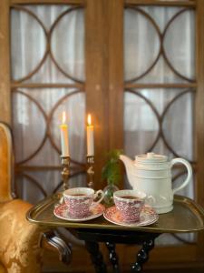 una bandeja con dos tazas de té y velas en una mesa en Nääs Slott en Floda