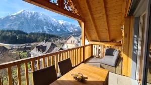 a balcony with a table and chairs and a mountain at die Tauplitz Lodges - Mountain view Lodge A11 by AA Holiday Homes in Tauplitz