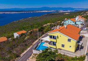 a yellow house with an orange roof and a swimming pool at Sun Villa in Dramalj