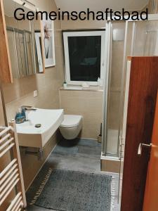 a bathroom with a sink and a toilet and a window at Luhne Boutique Pension in Rotenburg an der Wümme +68 photos