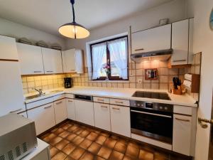 a kitchen with white cabinets and a sink and a window at Bergidyll in Garmisch-Partenkirchen