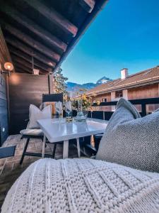 um pátio com uma mesa e cadeiras numa varanda em Bergidyll em Garmisch-Partenkirchen