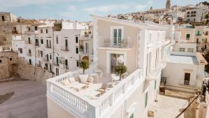 een uitzicht op een wit huis met stoelen op een balkon bij Tra Cielo e Mare in Vieste
