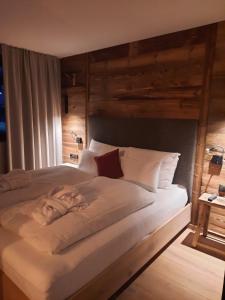 1 cama grande con sábanas y almohadas blancas en Mountain See Lodge, en See