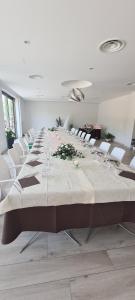 a large long table in a room with white chairs at Le Castella B&B Restaurant in Le Castella