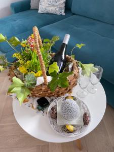 a basket of wine and flowers on a table at Apartament Zielone Zacisze in Jastrzębia Góra