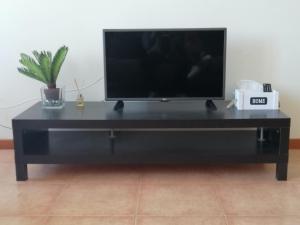 a black entertainment center with a flat screen tv on it at Casa Avó Rosa in Nazaré