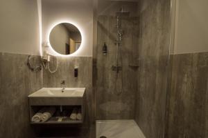 a bathroom with a shower and a sink and a mirror at Hotel Civitas in Sopron