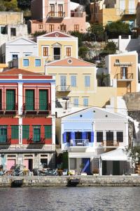 eine Gruppe von Häusern auf einem Hügel neben dem Wasser in der Unterkunft Cavo apartment in Symi