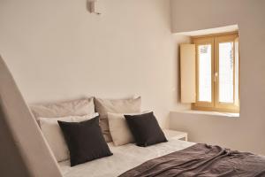 sypialnia z łóżkiem z czarno-białymi poduszkami w obiekcie TOWN BOX w mieście Mykonos