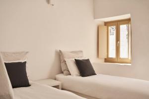 dwa łóżka w pokoju z oknem w obiekcie TOWN BOX w mieście Mykonos