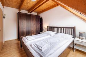 a bedroom with a large bed with a wooden headboard at Riviera Lipno 503 - 15 in Lipno nad Vltavou
