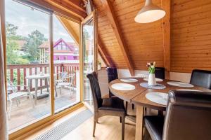 a dining room with a table and chairs and a balcony at Riviera Lipno 503 - 15 in Lipno nad Vltavou