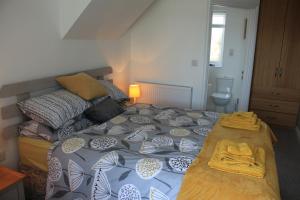 a bedroom with a bed with a blue and white comforter at Sea dream lodge -coastal location/sea views/self-contained in Southerndown