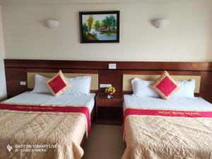 two beds sitting next to each other in a room at Khách sạn NHẬT MINH Cửa Lò in Cửa Lò