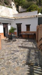 a stone patio with a table and a piano at Casa Cueva Sierra Nevada - Monachil in Monachil