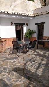 a patio with a table and chairs on a stone floor at Casa Cueva Sierra Nevada - Monachil in Monachil