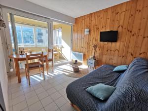 a bedroom with a bed and a table and a desk at Appartement T2 en résidence, centre ville d'Embrun in Embrun