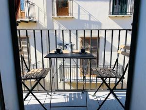 einen Tisch und zwei Stühle auf dem Balkon in der Unterkunft Sea house loft in Cefalú